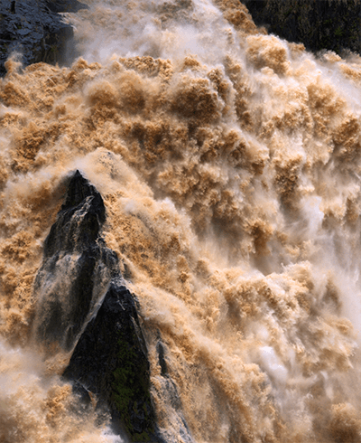 violent waterfall of murky water